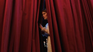 Actor looking through curtain
